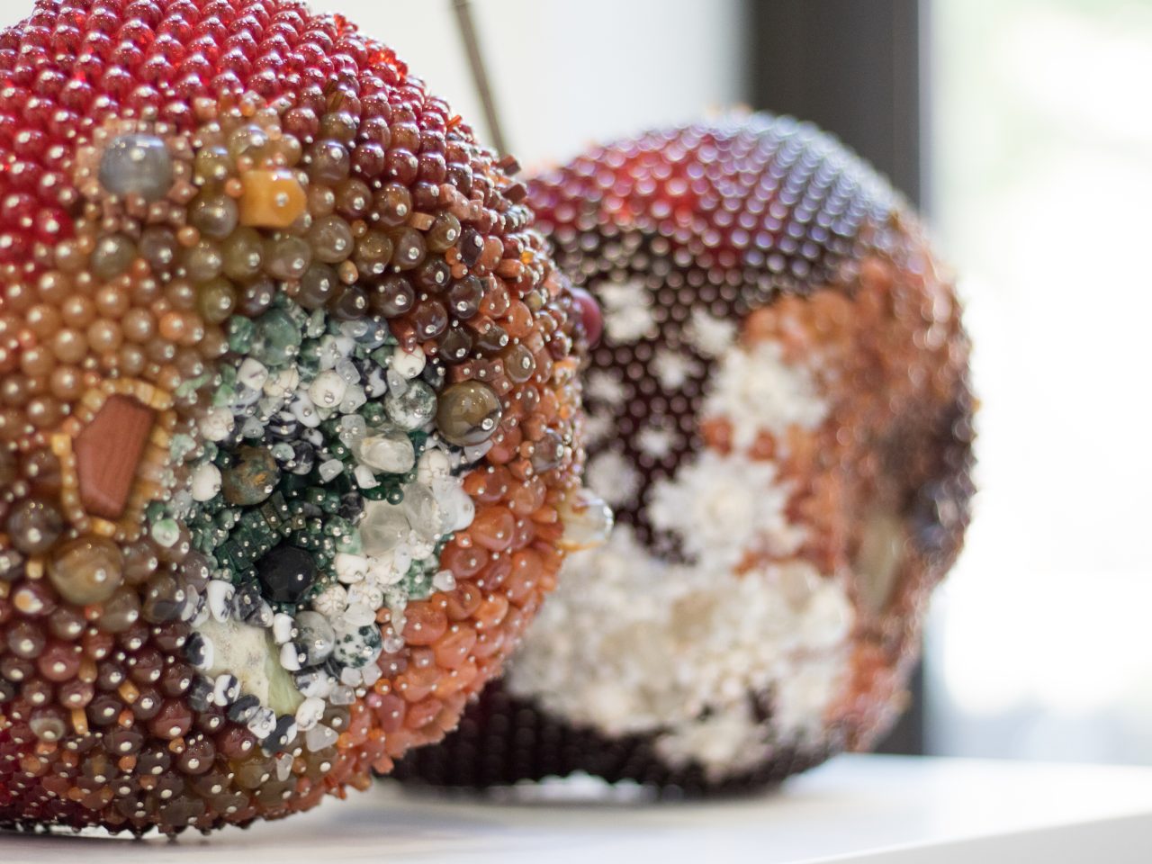 A large fruit sculpture in the shape of cherries. They are covered entirely by beads and crystals.