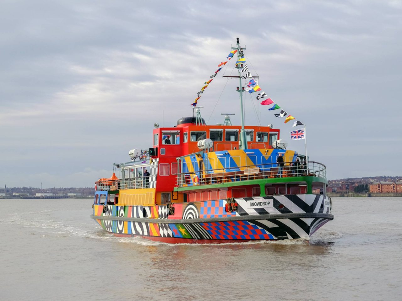 A colouful patterned ferry sailing across the River Mersey.
