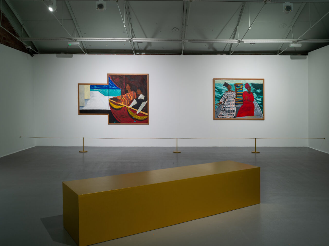 Two paintings on a wall. The first painting depicts two Black women seated at the opera, looking out at a seascape from their balcony seats. The second painting depicts Black female figures sitting on a boat in the middle of the sea.